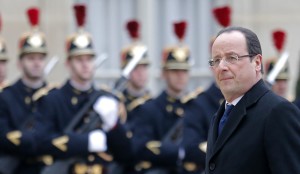 French President Francois Hollande walks past the honour guard as he arrives for a meeting with a guest at the Elysee Palace in Paris