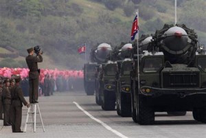 A North Korean soldier films military vehicles carrying missiles during a parade to commemorate the 65th anniversary of founding of the Workers' Party of Korea in Pyongyang
