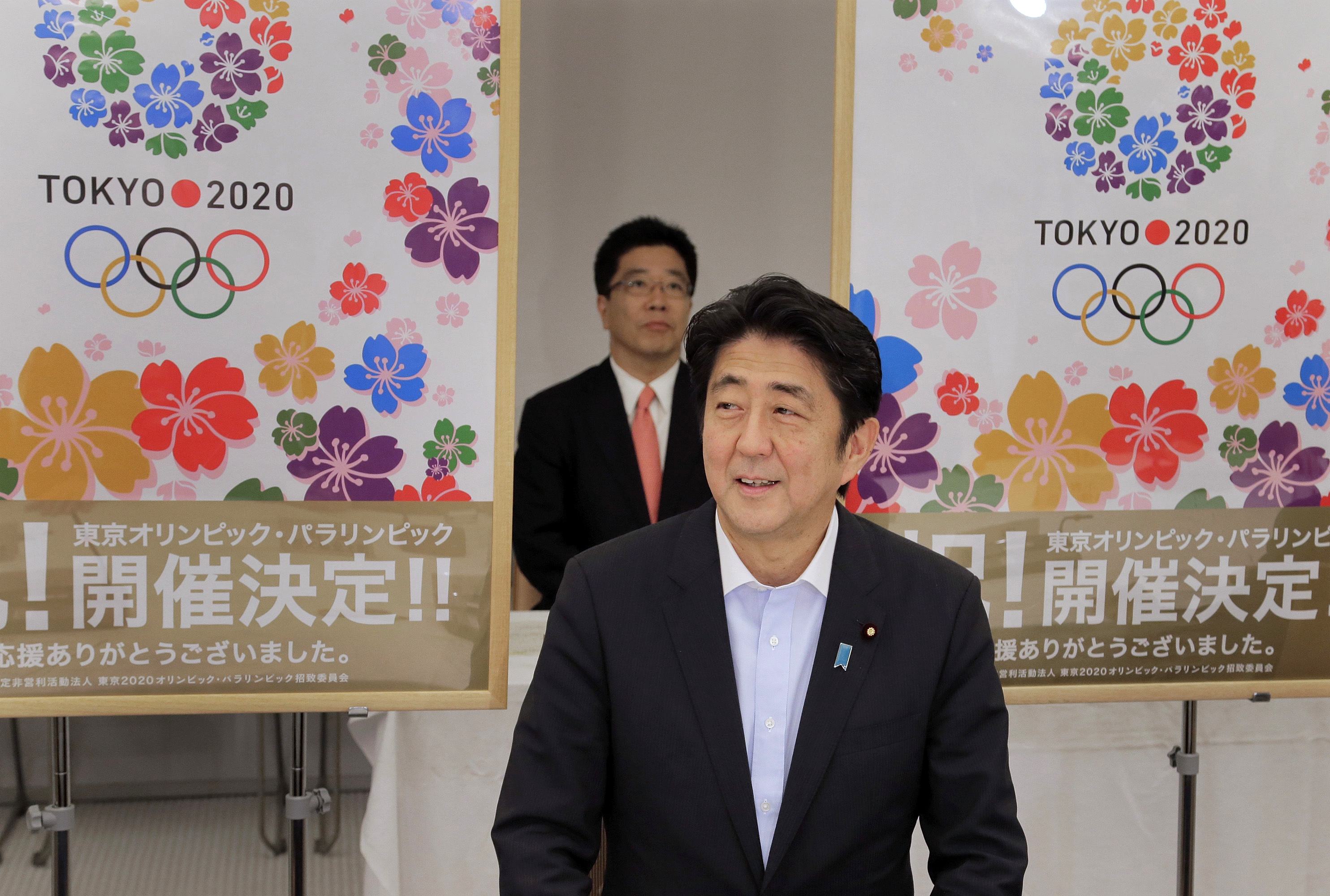 Japan's Prime Minister Abe smiles as he reports to his cabinet members Tokyo's successful bid to host the 2020 Summer Olympics and Paralympics in Tokyo