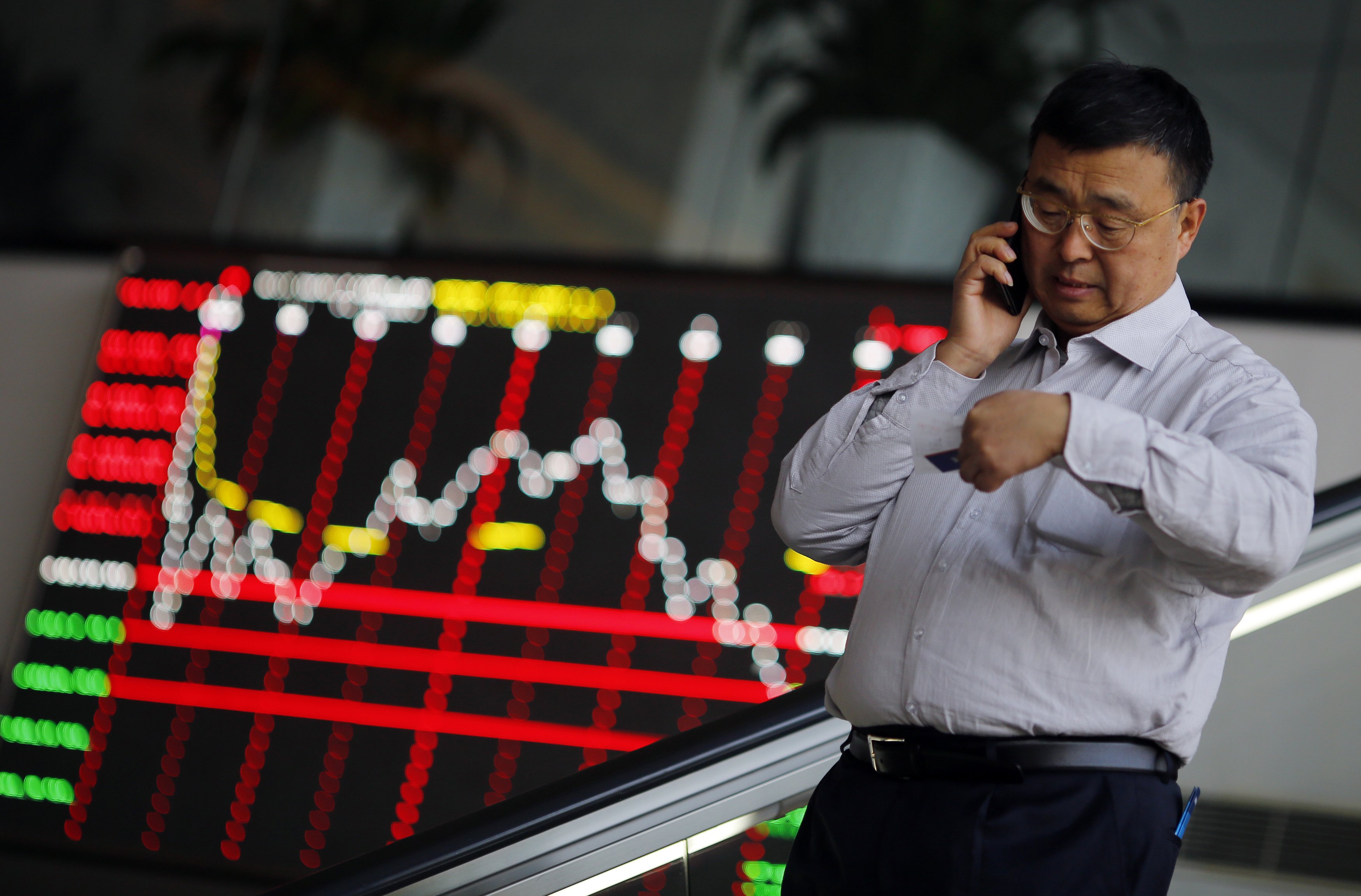 A man talks on the phone inside the Shanghai Stock Exchange building at the Pudong financial district in Shanghai